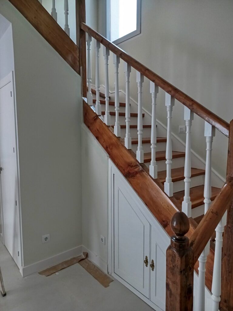 Escalera lacada en blanco con pasamanos de madera, después del lacado